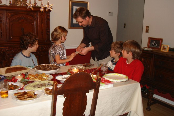 a father sharing the opłatek wafer with his daughter.